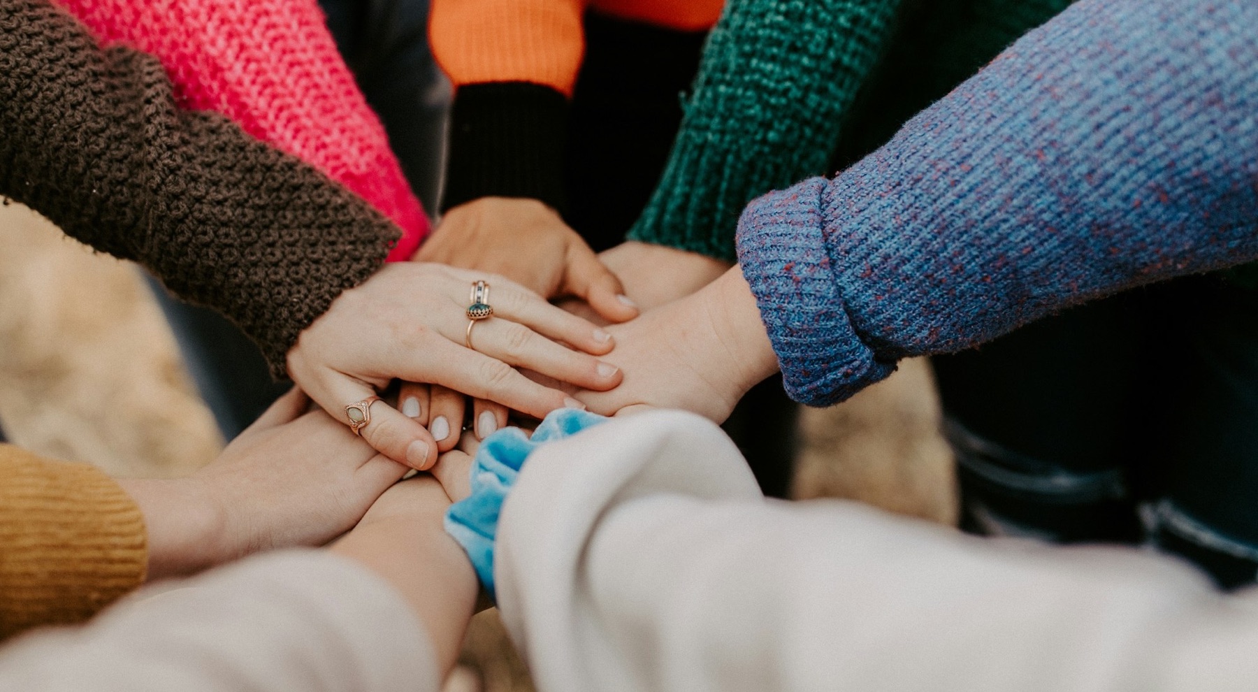 Hände verschiedener Menschen liegen übereinander – gemeinsames Engagement